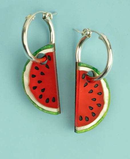 Watermelon slice earrings on a light blue background