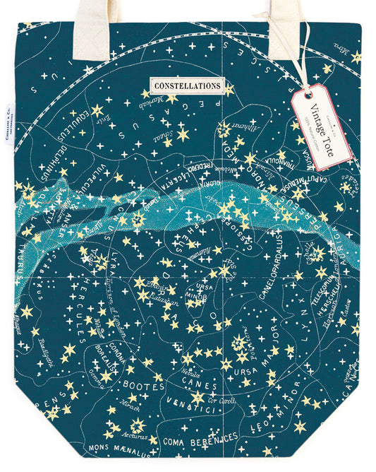 A tote bag with a celestial and star pattern, predominantly dark blue or black, with constellations labeled in white and yellow text.