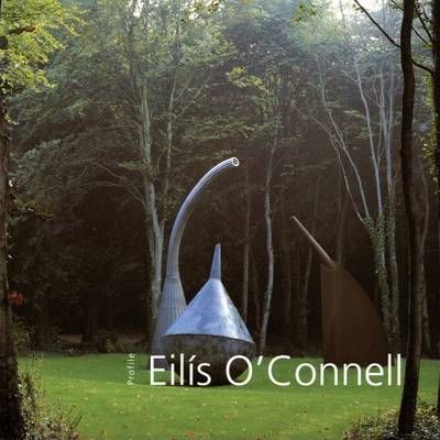 A photograph of a sculpture in a forest. The sculpture looks like a large smooth metal spinning top with another metal piece coming up from from the ground and curving over. The title is in the bottom left in white.